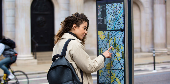 A woman trying to navigate using wayfinder signage