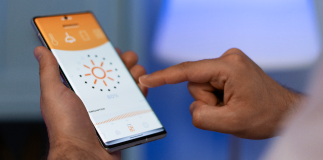 Man holding a phone the UI showing lighting control