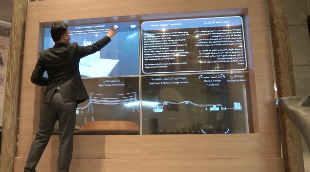 Man interacting with transparent digital screen featuring immersive AV content in a visitor attraction centre