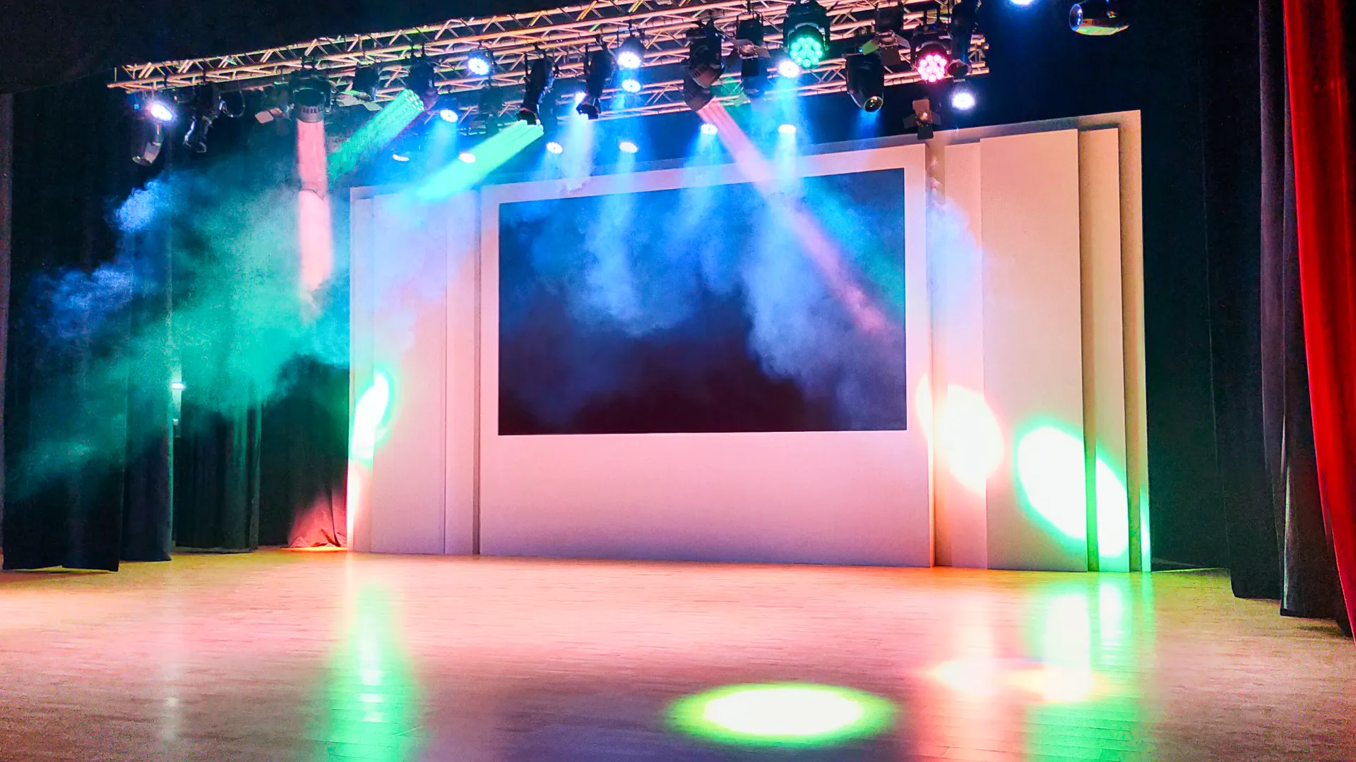 Al Ain Municipality auditorium stage with central projection screen theatre truss and dynamic lighting effects installed by Oxford Integration